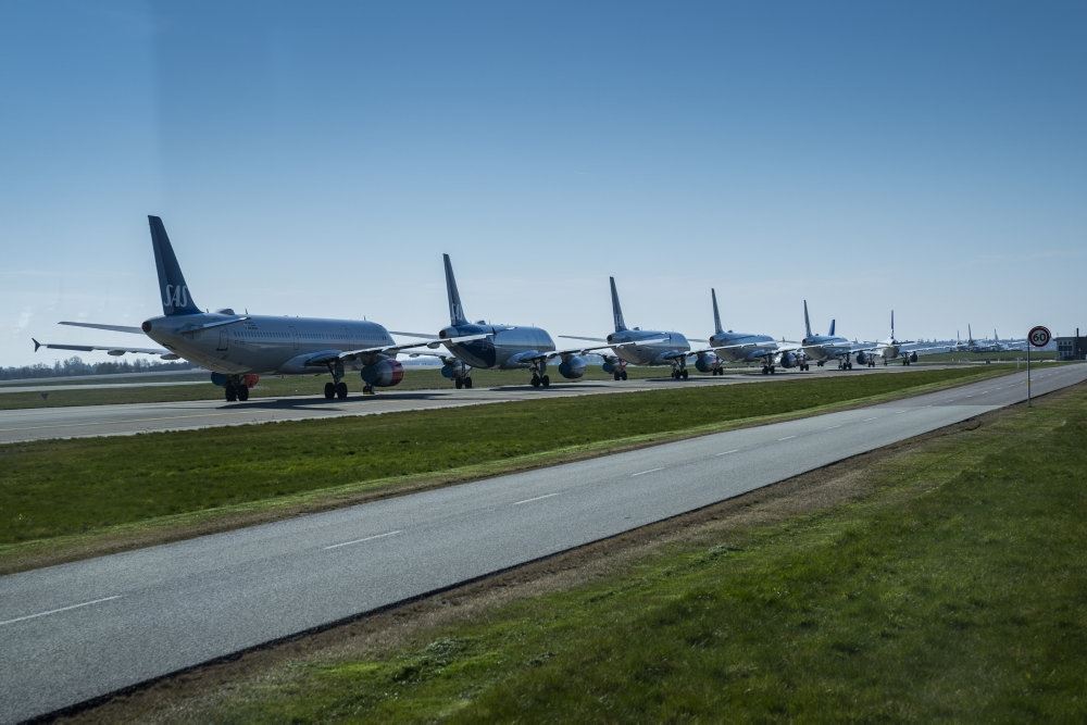 lang række af fly står på startbanen