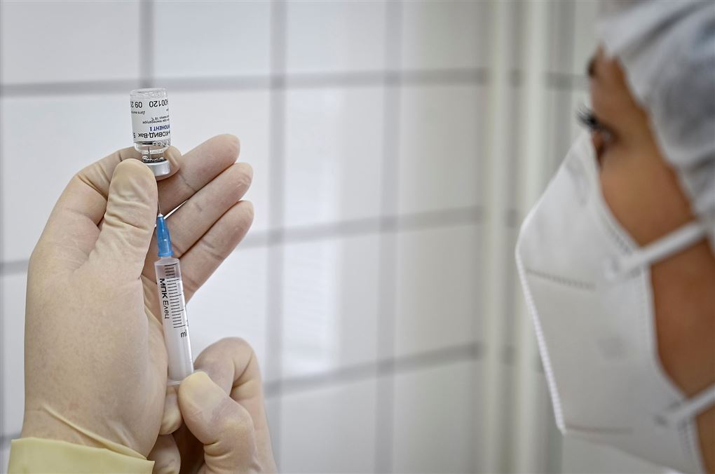En læge eller sygeplejerske trækker vaccine i en kanyle.
