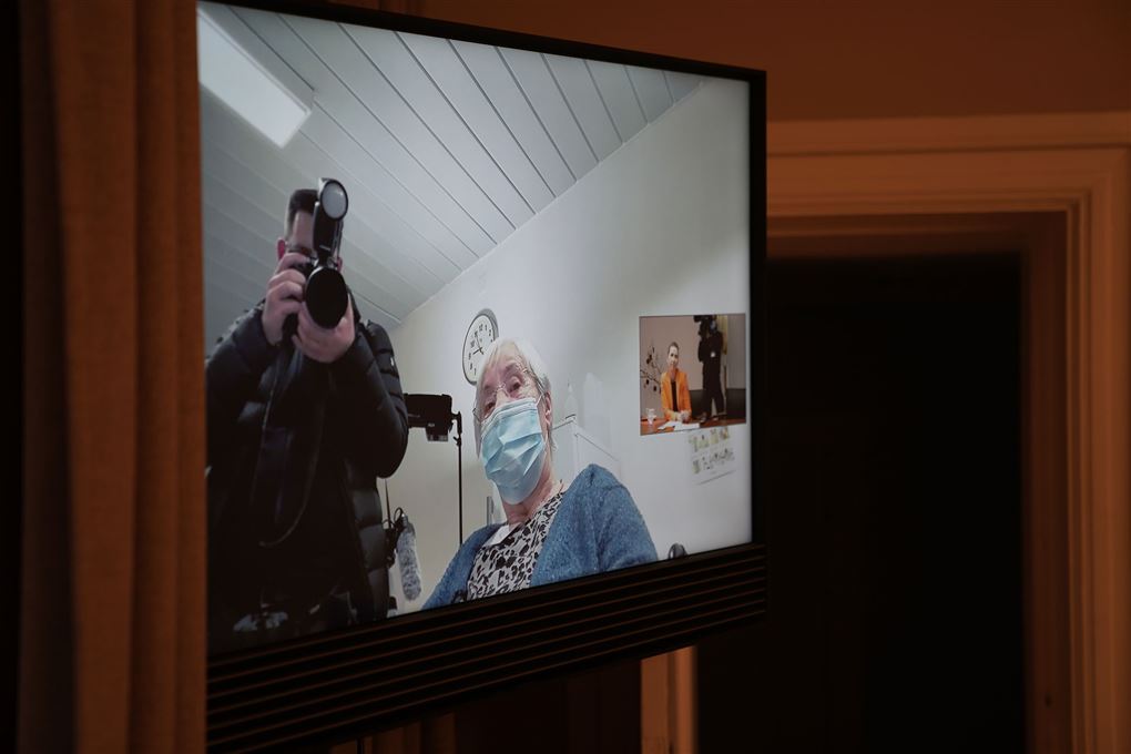 En videoskærm med en ældre kvinde og et lille billede af Mette Frederiksen