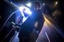 En politibetjent foretager en alkometertest på en bilist  i mørke.