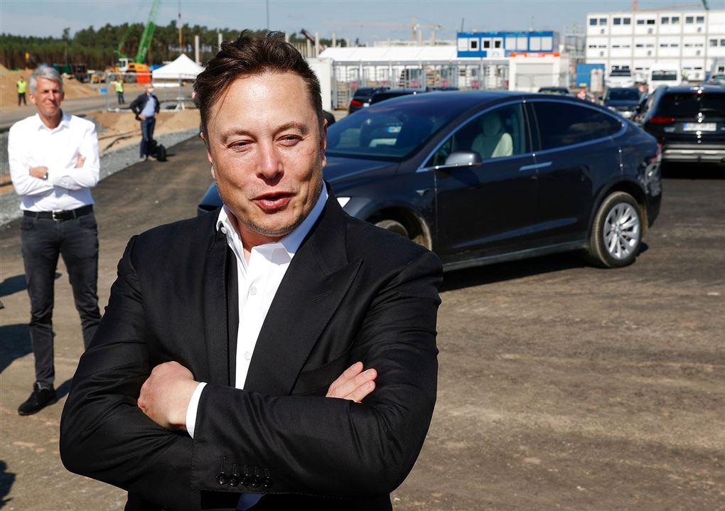 Elon Musk foran en Tesla