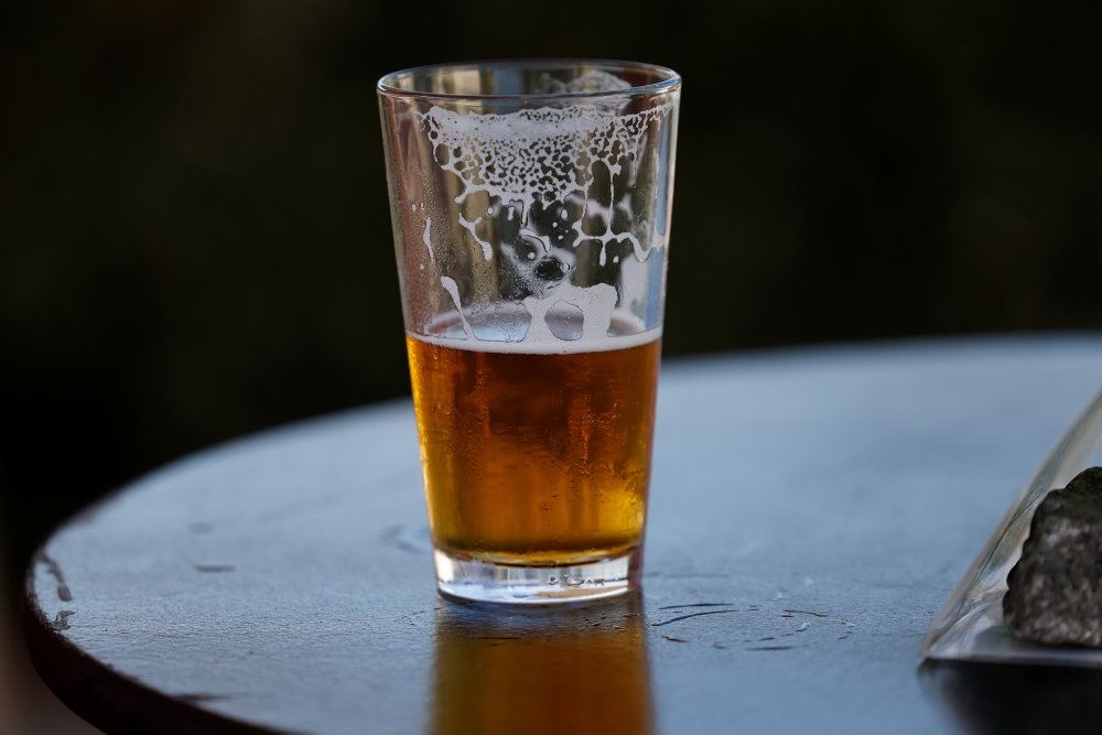 Et halvfyldt glas øl på et bord