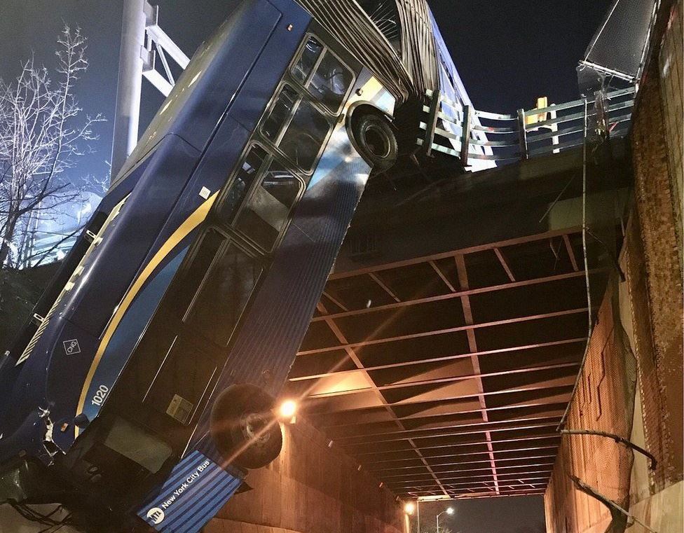 forreste del af en tandembus hænger og dingler ud over en bro i New York