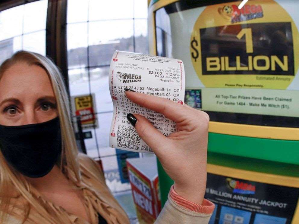 kvinde med mundbind viser lottokupon