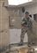 En soldat med en riffel i en sønderskudt bygning