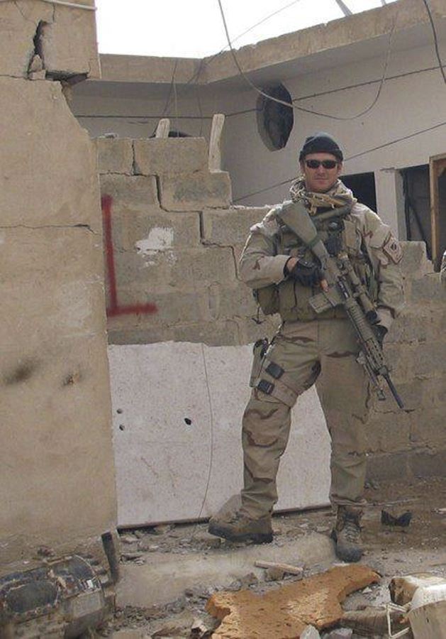 En soldat med en riffel i en sønderskudt bygning