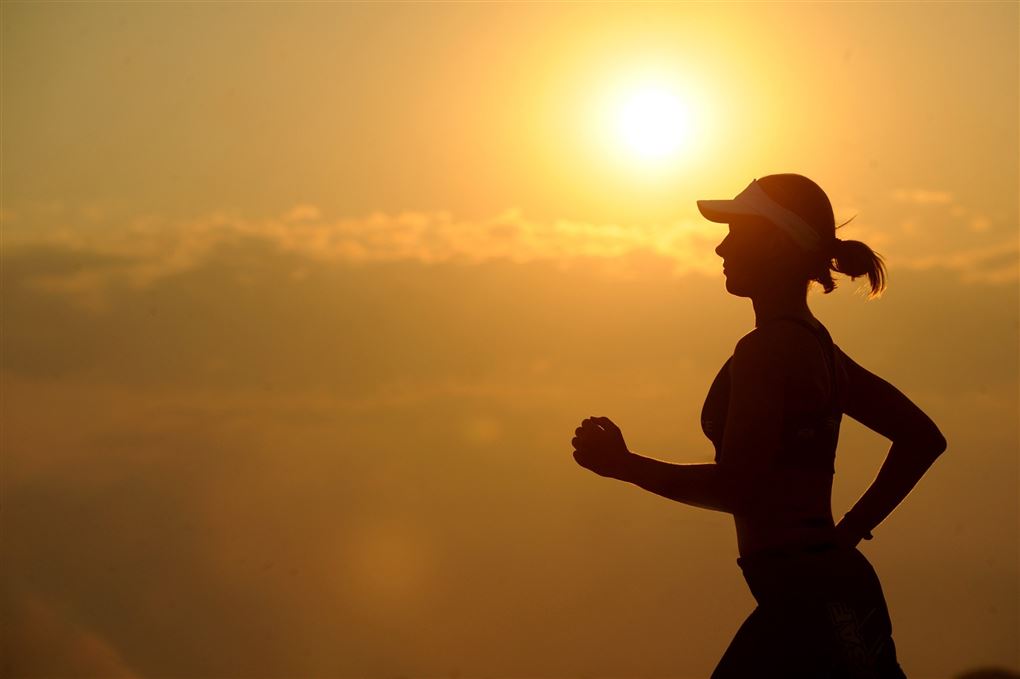 Kvinde løber i solnedgangen