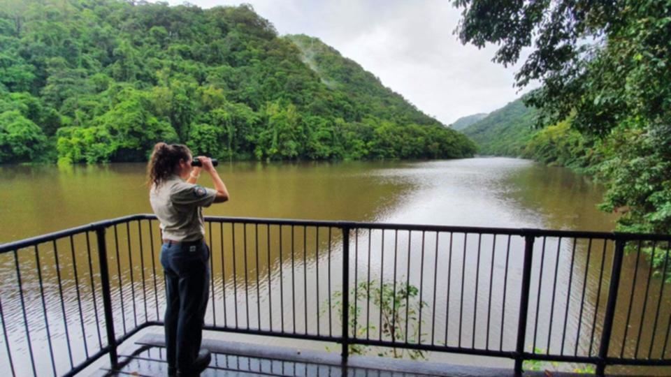 en kvinde med kikkert kigger ud over sø