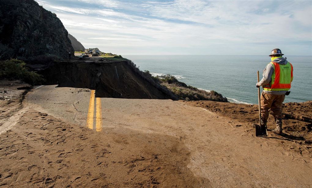 mand går ved hul i vejen ved kysten i Californien