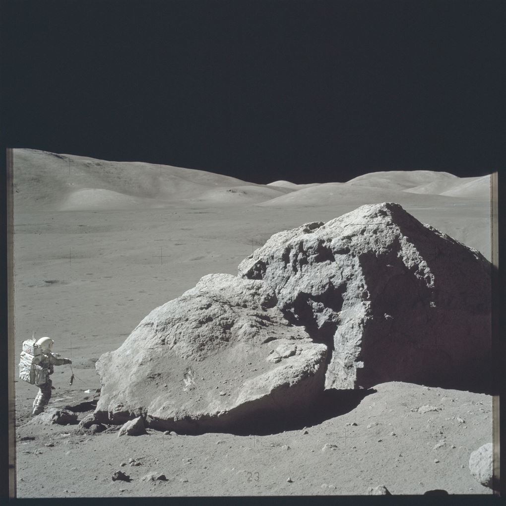 En mand ved en kraterklippe på Månen