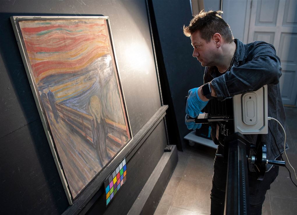mand undersøger maleri med infrarød scanner