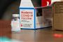 vaccineglas fra virksomheden moderna står på et bord
