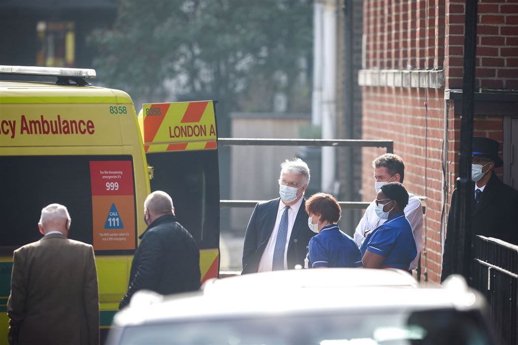 folk står ved ambulance uden for hospital 