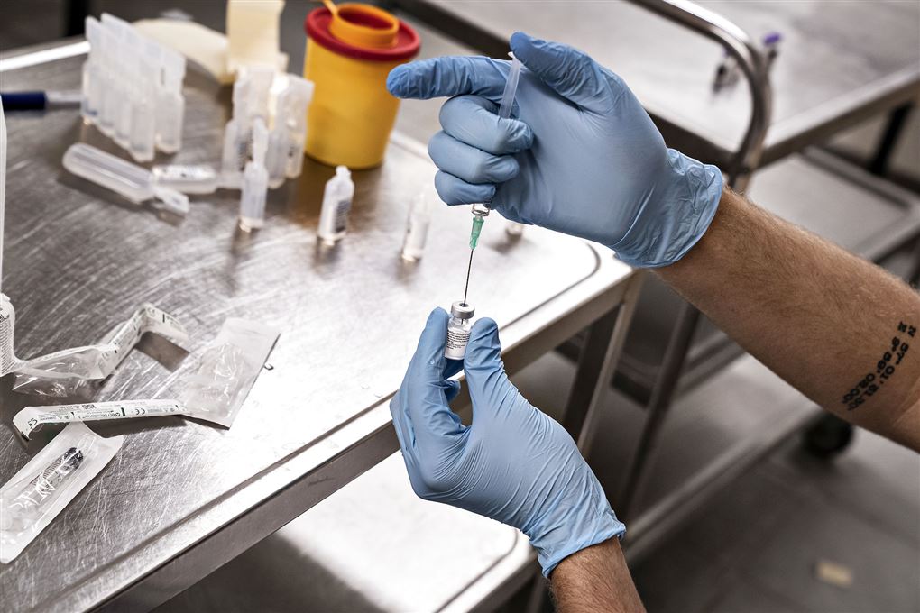Sundhedspersonale der fylder vaccine i en kanyle. 
