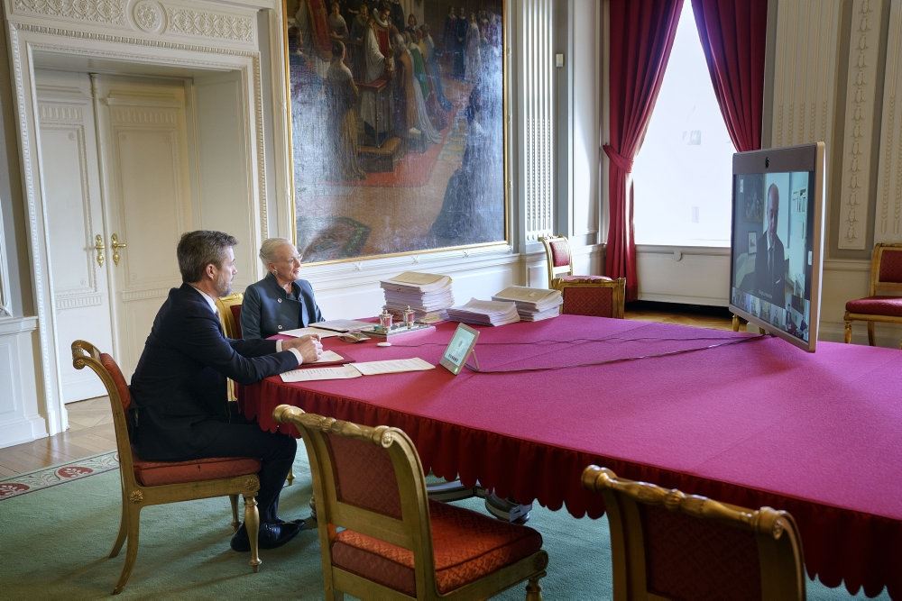 Dronningen og kronprins Frederik ved et stort bord
