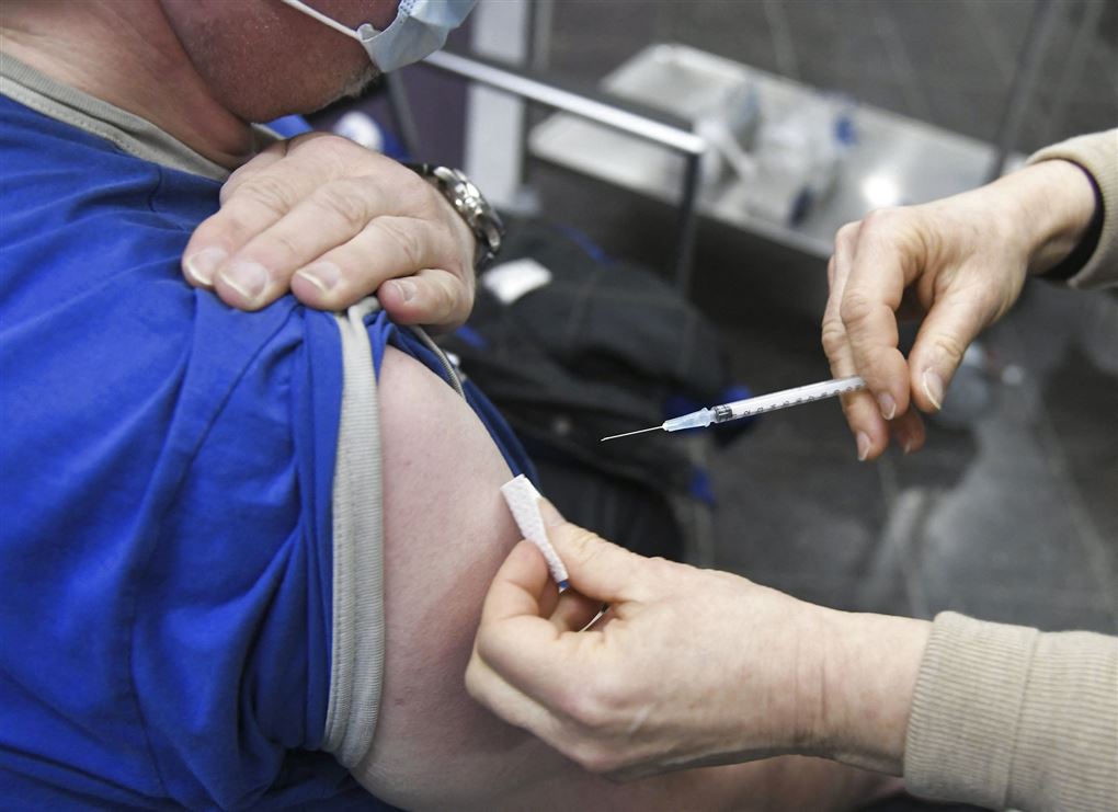 En person bliver stukket i skulderen med vaccine. 