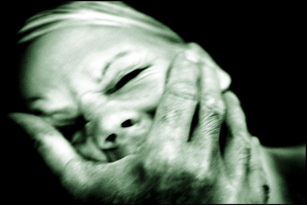 En kvinde bliver holdt for munden af en stor hånd mens hun græder og skriger. 