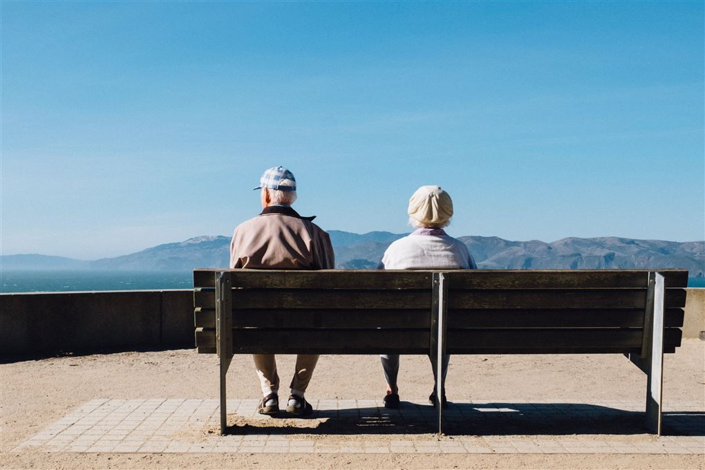 Et ældre par sidder på en bænk
