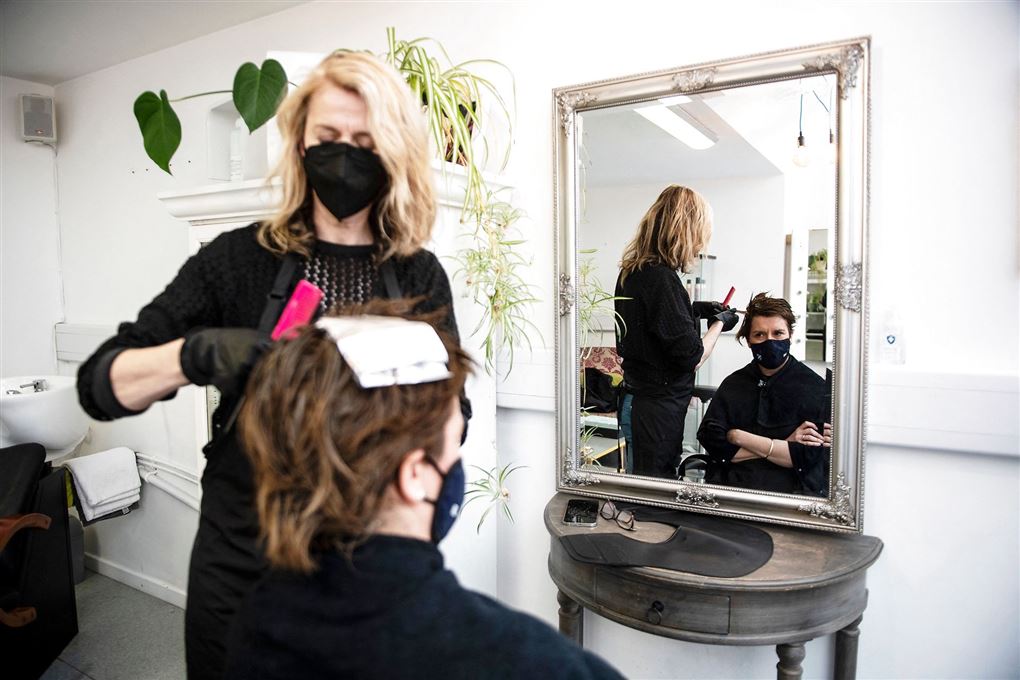 kvinde får klippet hår hos frisøren