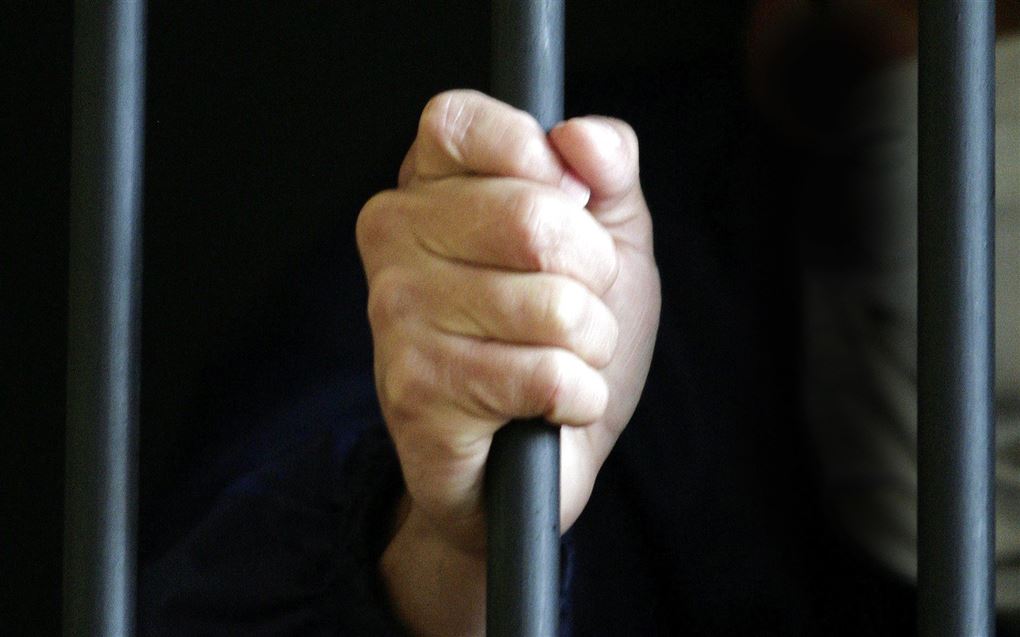 billede af hånd der holder om tremme