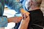 mand får vaccination med et stik i skulderen