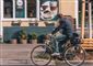 mand på cykel kører forbi café