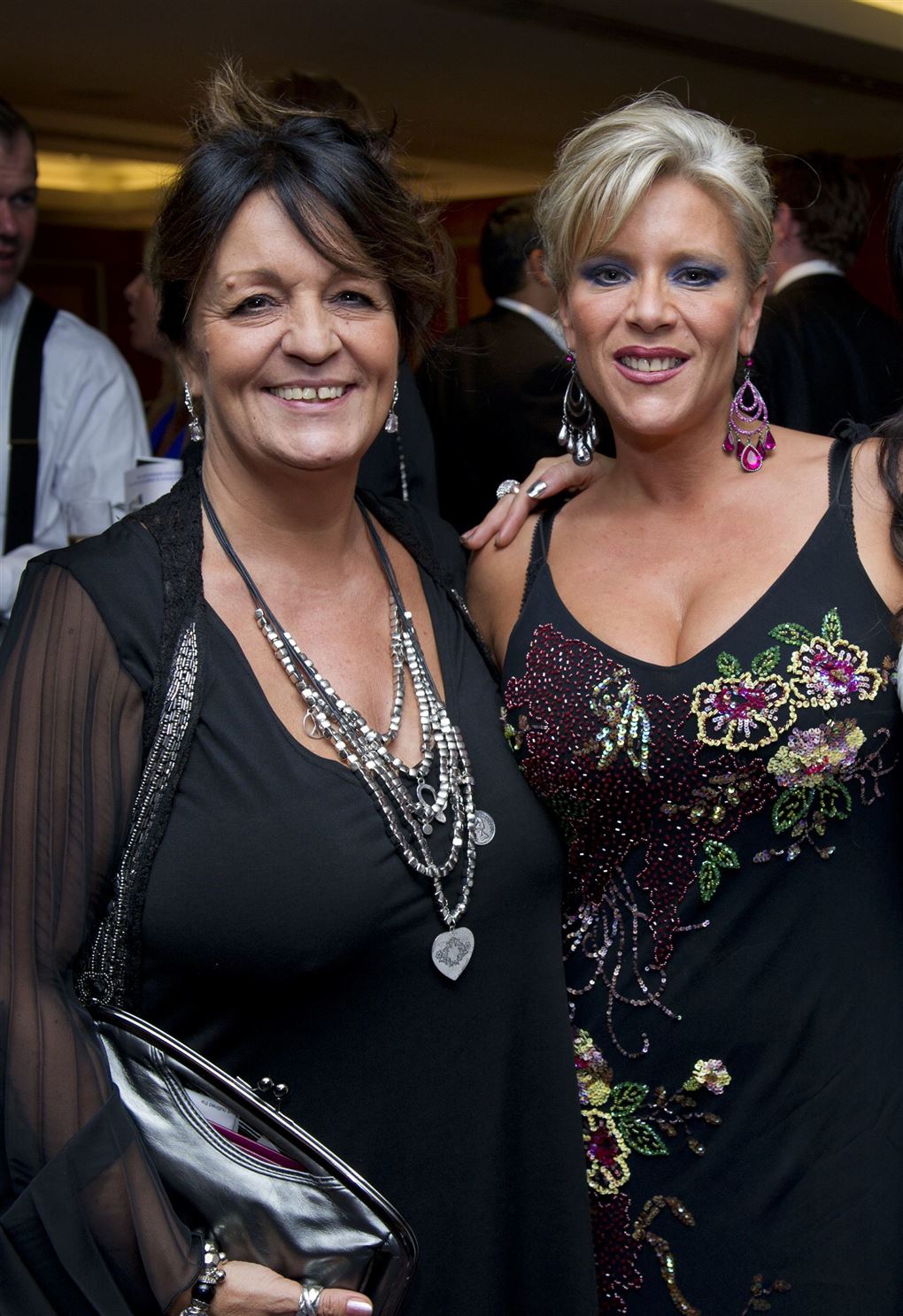To kvinder i sorte kjoler smiler