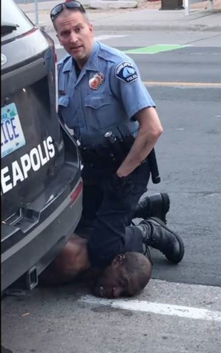 En betjent sætter knæet i halsen på en sort mand