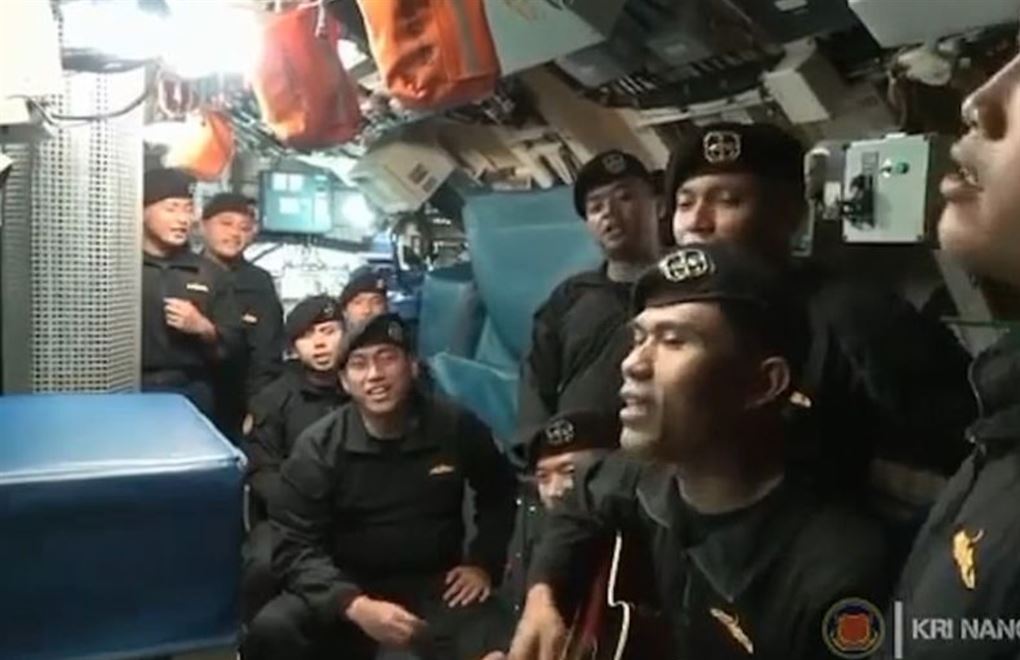 Nogle soldater i en ubåd spiller og synger