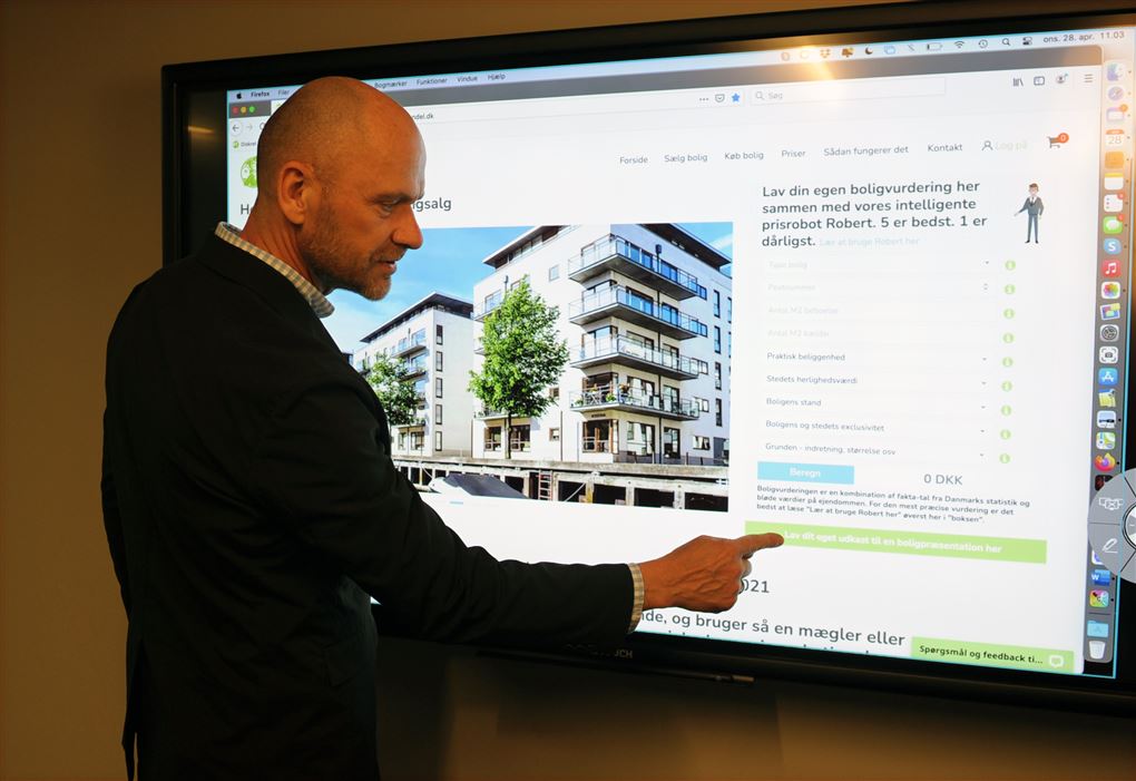 En mand peger på en bygning på en skærm