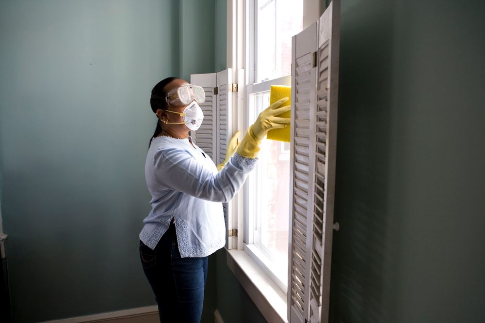 kvinde gør rent ved vindue