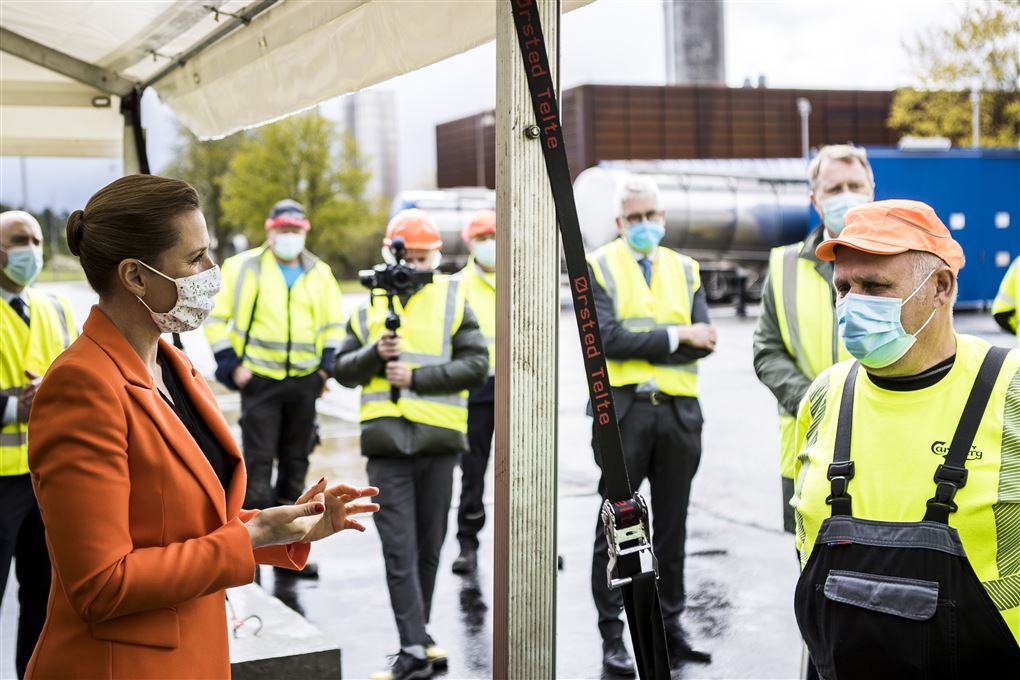 Mette F snakker med arbejdere i gult tøj