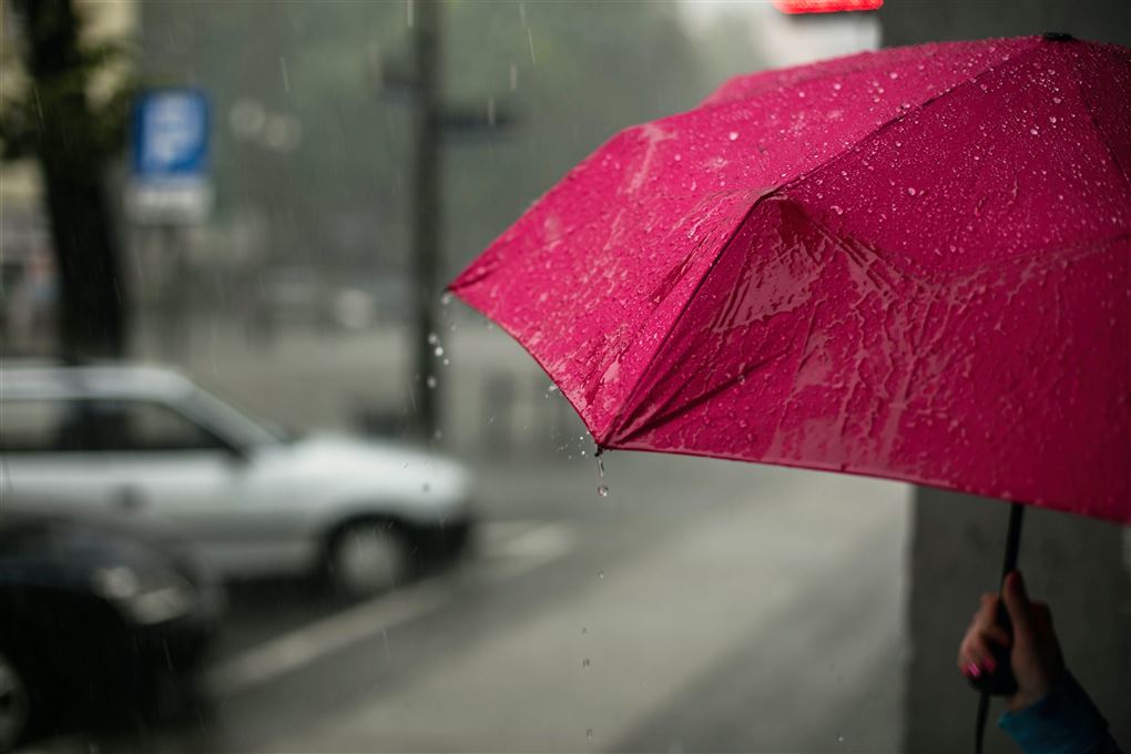 En rød paraply på en gade i regnvejr. 