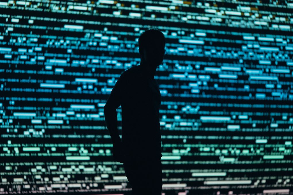 En mand står foran en kæmpe skærm med data