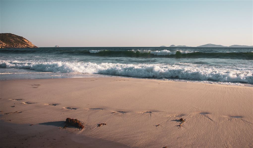 En strand med bølger og sol