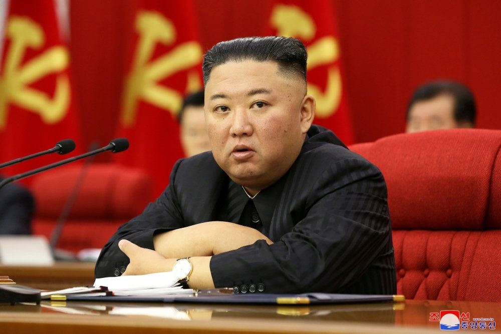 Kim Jong-un med korslagte arme i en stor rød stol. Han ser ikke specielt udmagret ud.