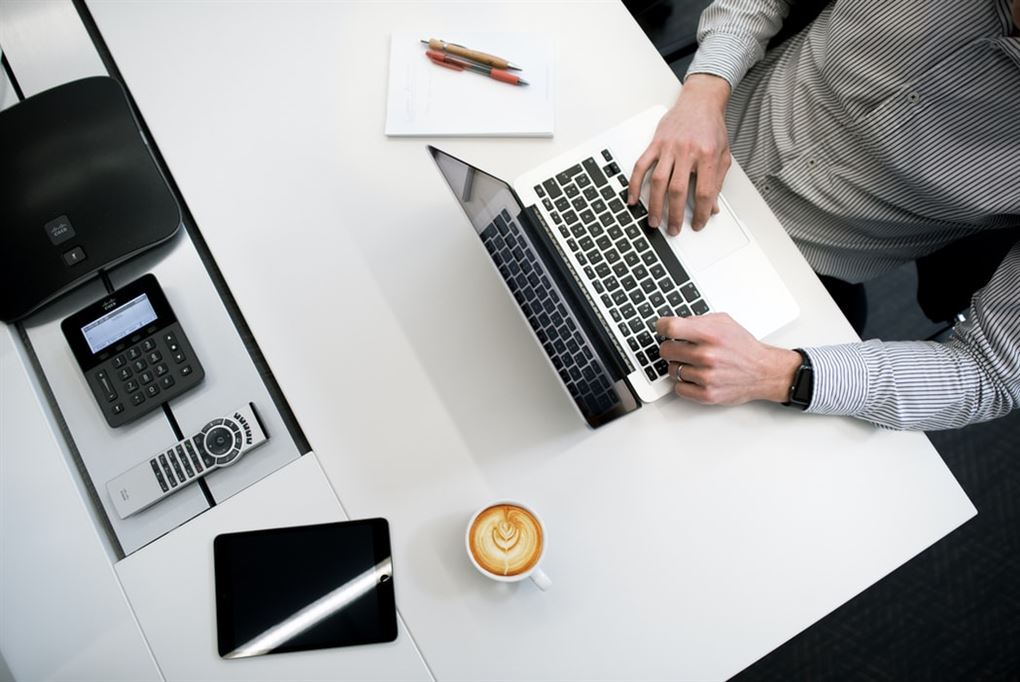En mand sidder ved computer laptop