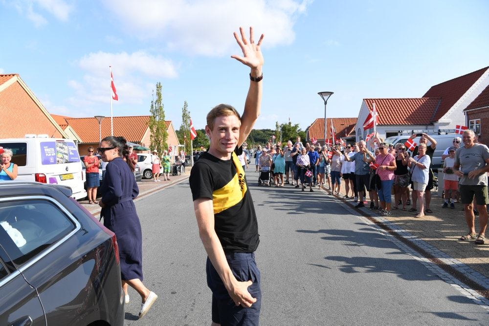 En mand vinker ved en gade
