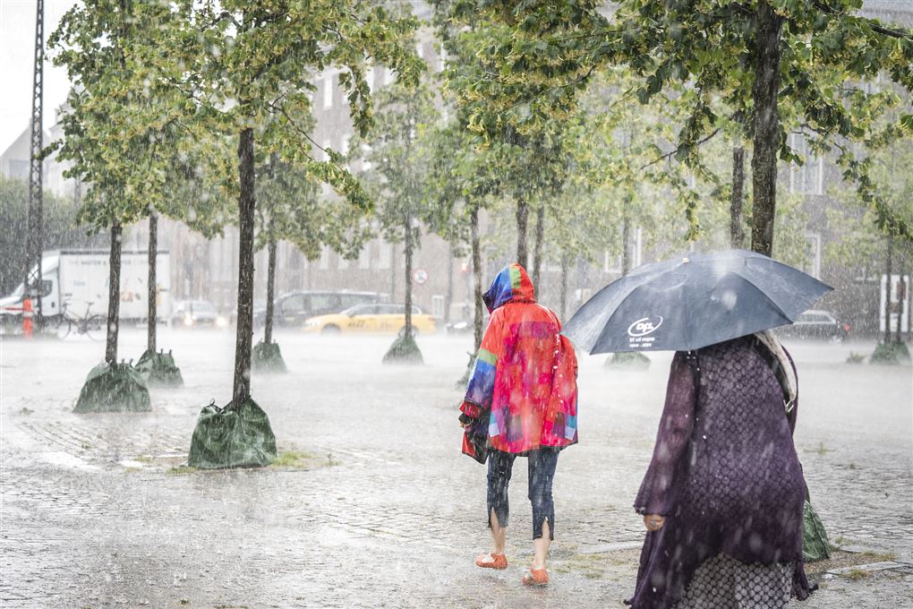 Folk går i sjoskende regn på et torv