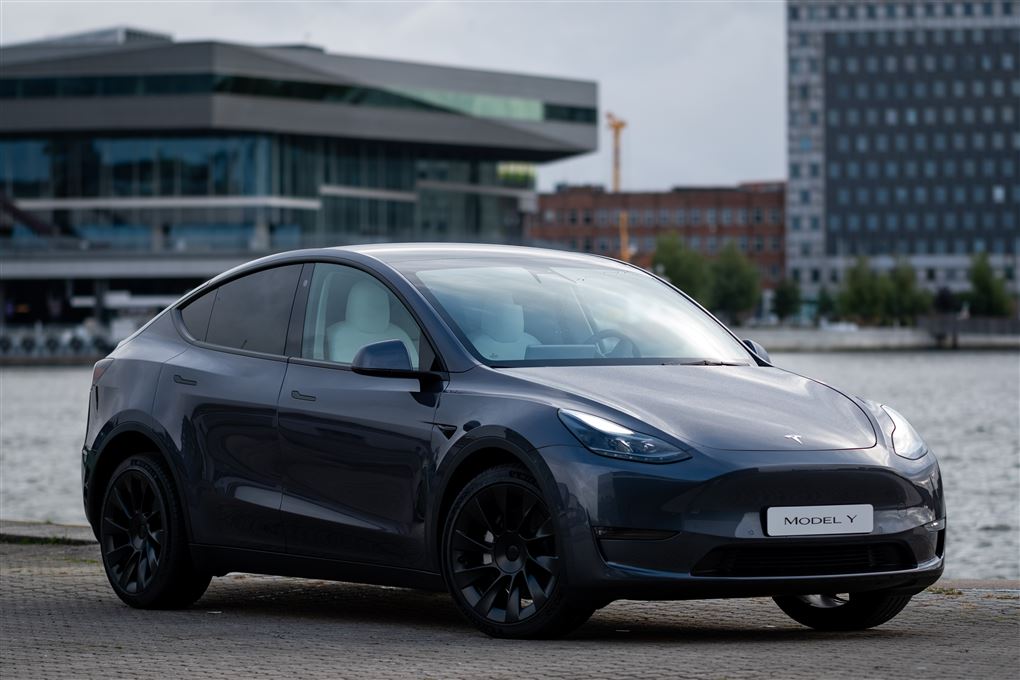 En grå Tesla ved en havnefront