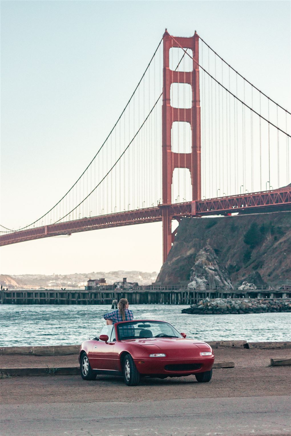 En lille sportsvogn foran en stor rød bro