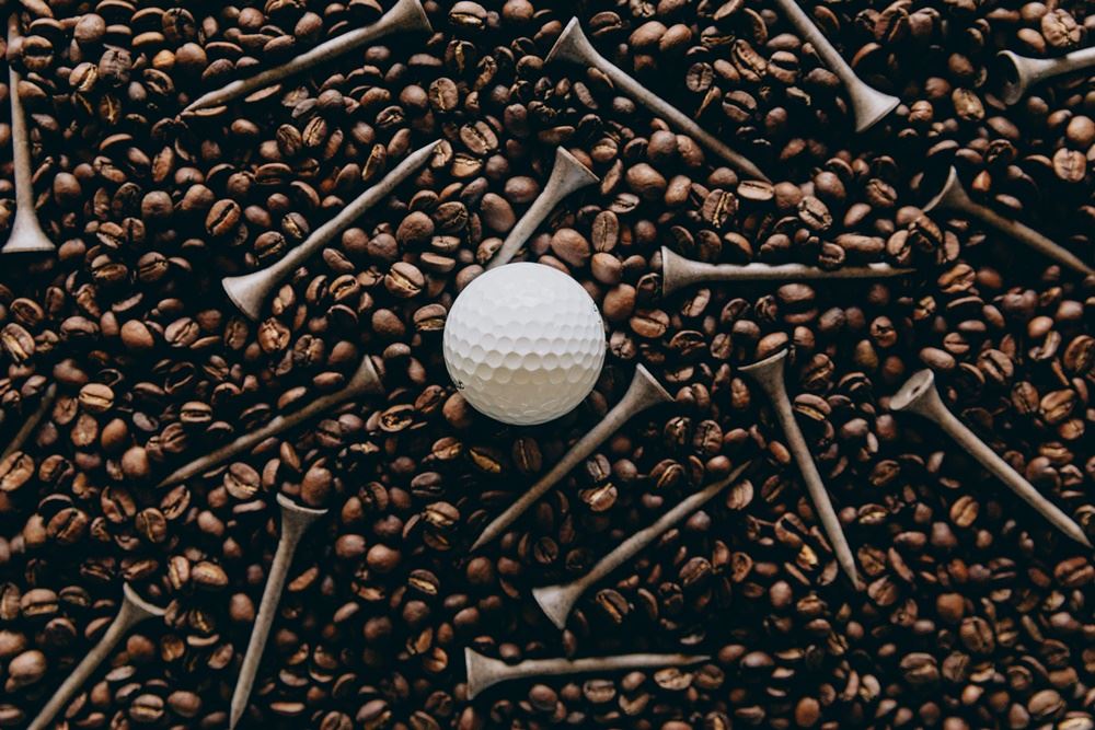 En golfbold og nogle tees i kaffebønner