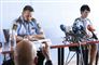 to politifolk sidder ved bord ved pressemøde 