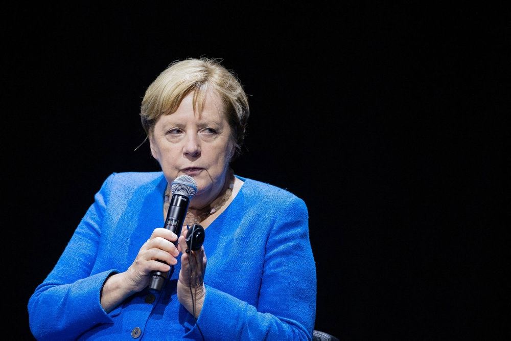 Angela Merkel med en skrigende blå jakke og et alvorligt blik