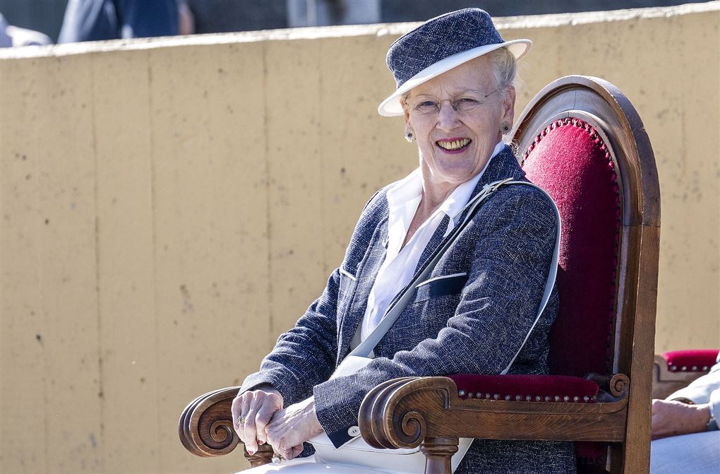 Dronning Margrethe sidder på stol og smiler 