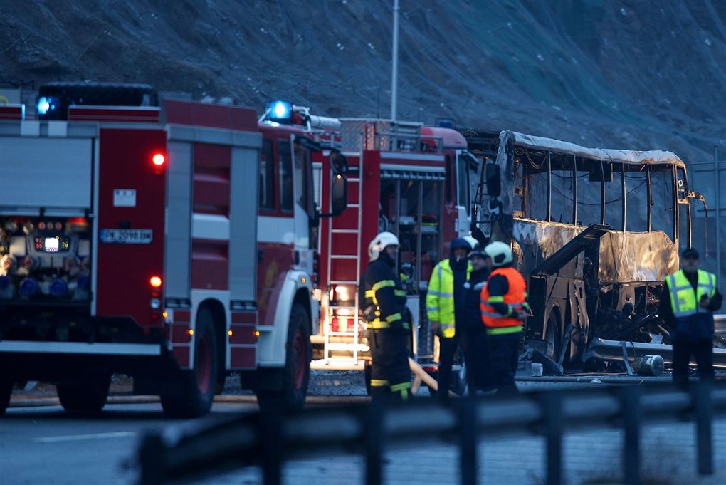 Den udbrændte bus omringet af brandfolk og teknikere, der undersøger, hvorfor den brød i brand. 