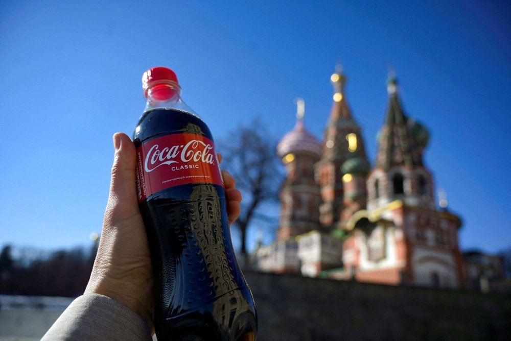 Coco-Cola flaske med russiske bygninger i baggrunden