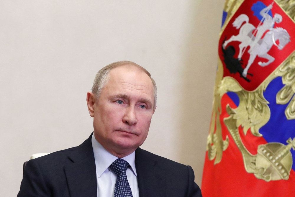 vladimir putin sidder i mørk jakke