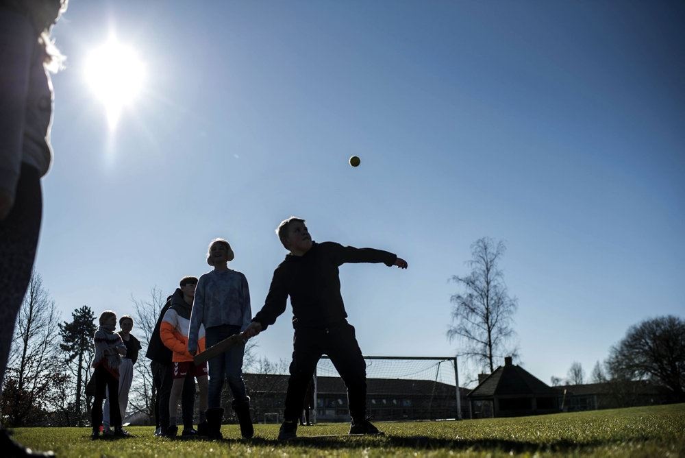 personer står udenfor under blå himmel