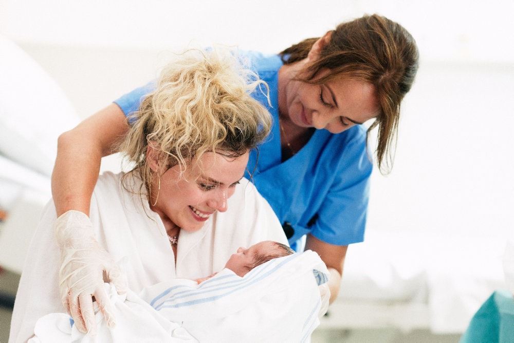 En sygeplejerske med en nyfødt og en mor